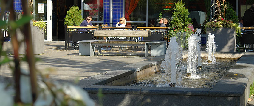 Fontänen på torget i Bollebygd med restaurangbesökare i bakgrunden