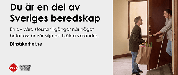 En man lämnar över en matkasse till en kvinna i en dörröppning. Texten lyder: Du är en del av Sveriges beredskap.