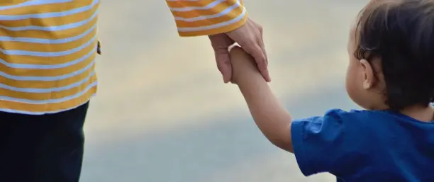 Barn som håller förälders hand