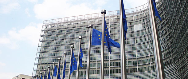 EU-kommission med EU-flaggor stående utanför